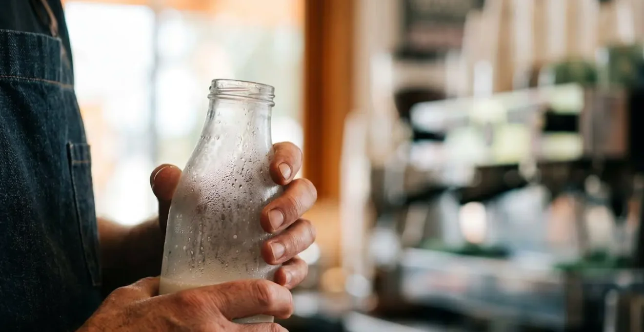 Close-up of hands working with fresh dairy products and planning tools in cafe kitchen environment